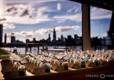 In the foreground, a table holding place cards and packaged, handmade soaps. In the background, an unfocused view of the Chicago skyline, seen over the water.