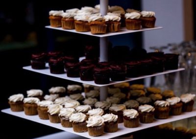 A square, four-tier cupcake stands full of cupcakes.