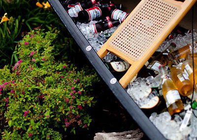 A canoe on its side in a garden, filled with ice and beer.