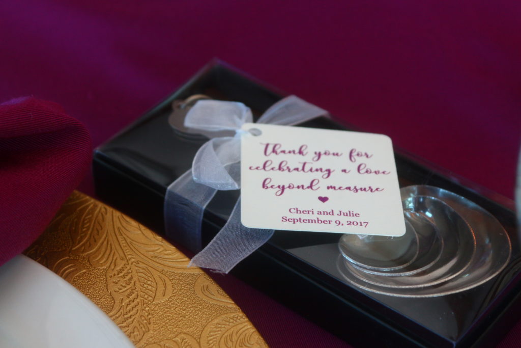 A box containing heart-shaped measuring spoons with a gift tag and ribbon.  The tag reads, "Thank you for celelbrating a love yehond measure."