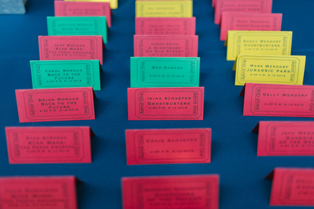 Place cards in rows on a table. Each one is designed as a movie ticket.