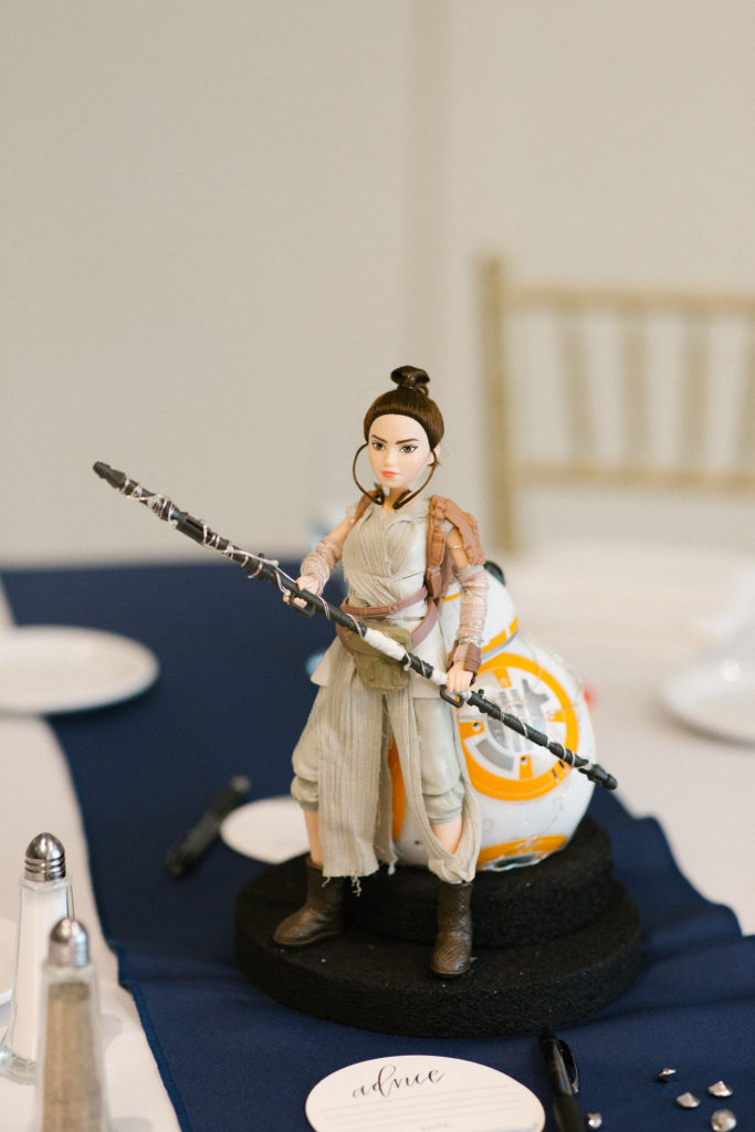 A model of a Star Wars character carrying a long weapon, with a droid behind her. 