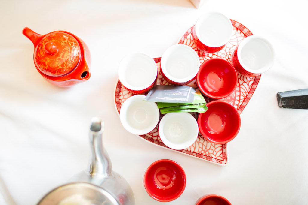 A red and white Chinese tea set, seen from above.